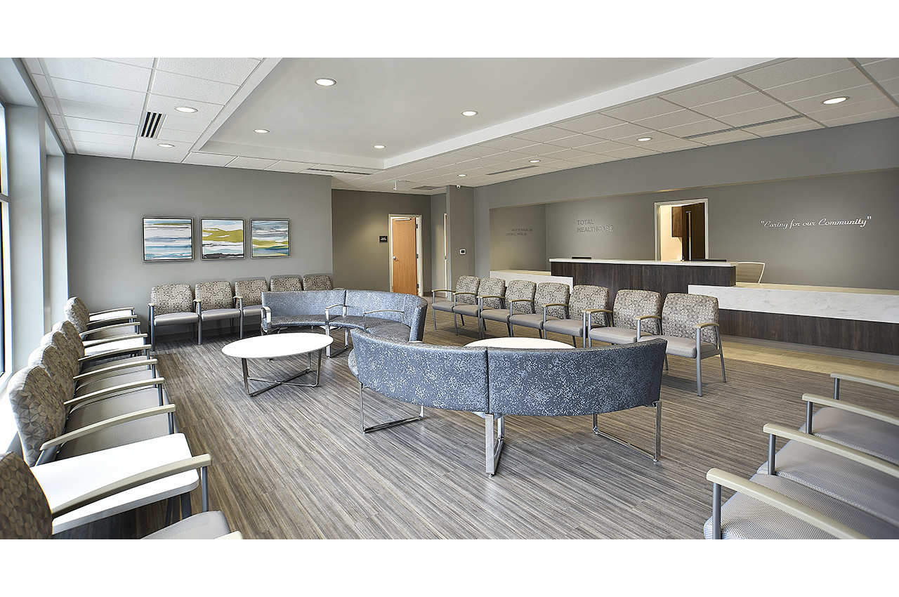 total healthcare waiting room at russell medical center including curved lounge seating, colorful artwork, and timeless wood textures